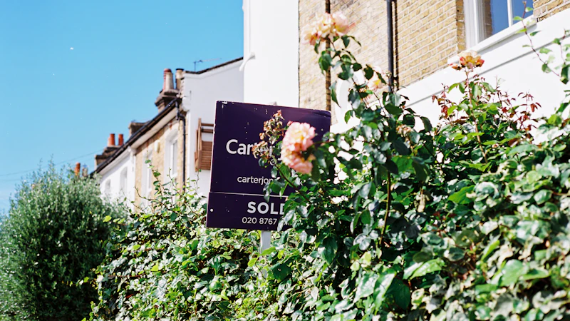 A sold sign and roses outside a house in the UK