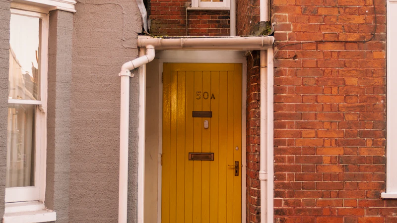 A brick building with a yellow door and window