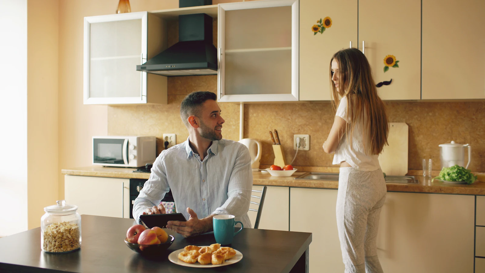 A couple talking in a modern kitchen during breakfast