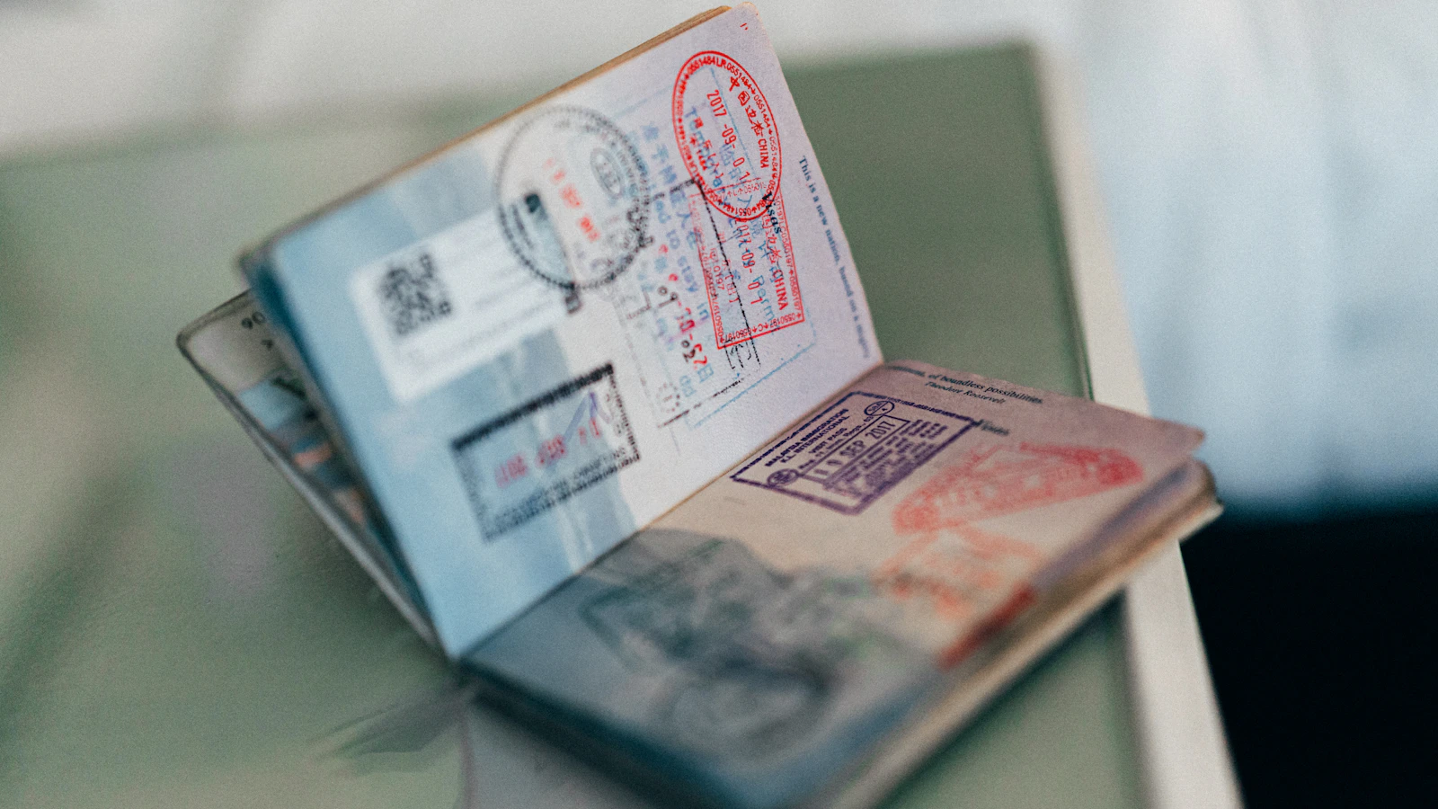 An open passport with multiple colorful ink stamps on the pages