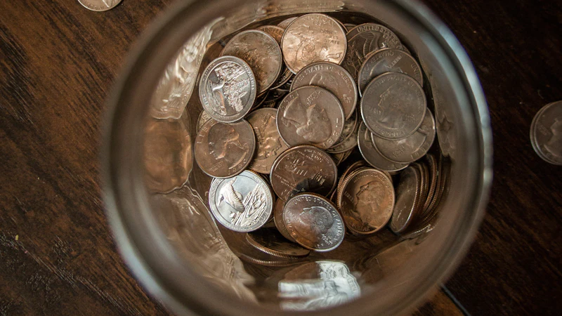 Silver round coins on a clear glass jar