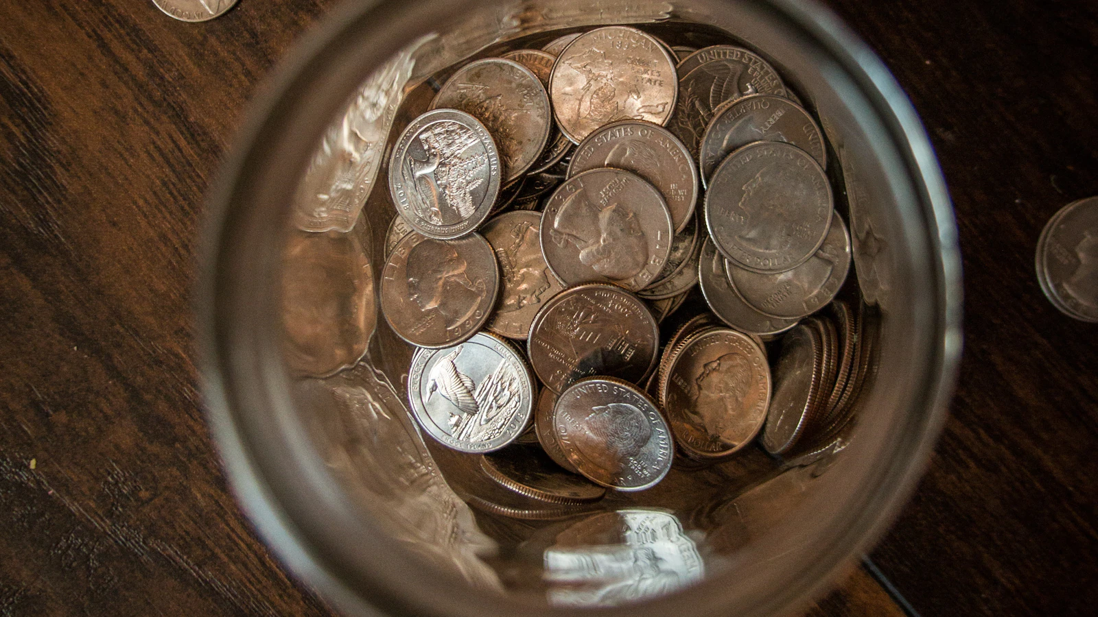 Silver round coins on a clear glass jar